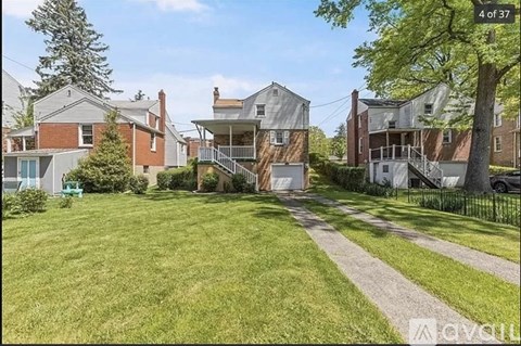 A house with a green lawn and a tree in front of it.