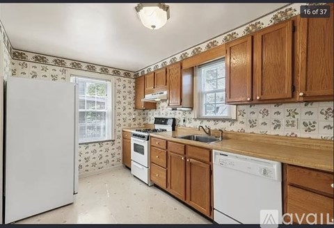 A kitchen with wooden cabinets and a white fridge.