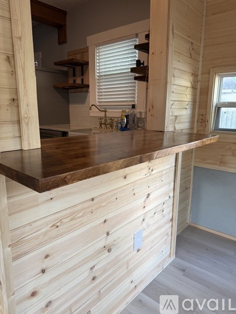 A wooden kitchen counter with a window above it.