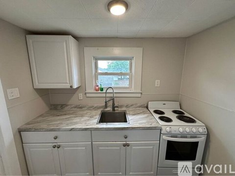 A kitchen with a marble countertop and a window.