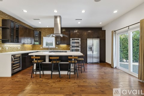 A modern kitchen with dark wood cabinets and a center island.