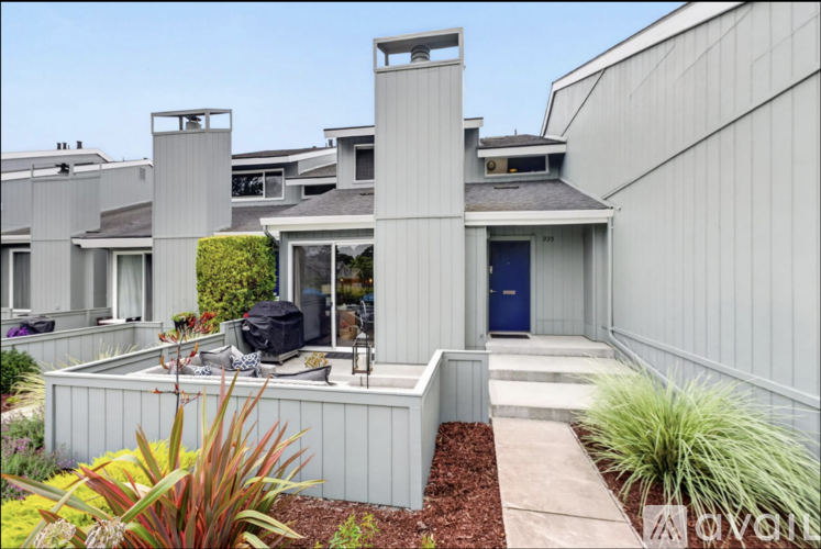 A modern house with a blue door and a white exterior.