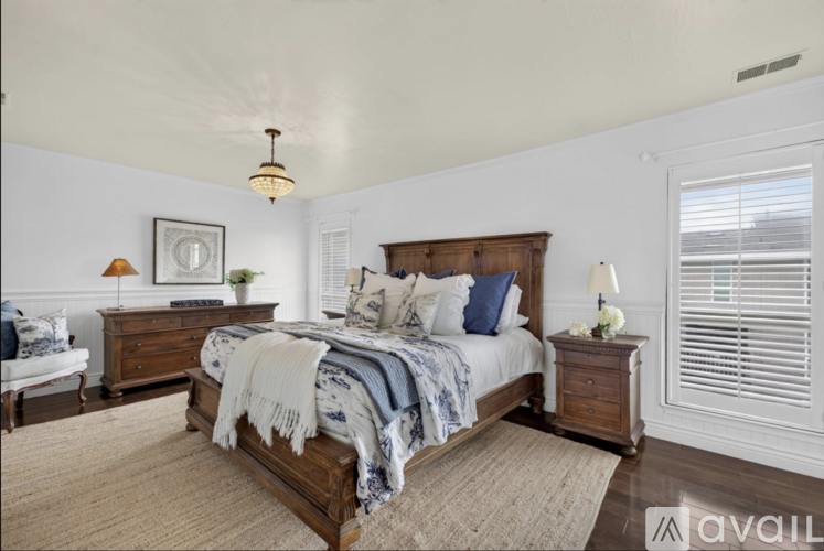 A bedroom with a bed, nightstand, and lamp.