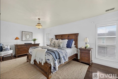 A bedroom with a bed, nightstand, and lamp.