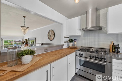 A modern kitchen with a wooden countertop and stainless steel appliances.