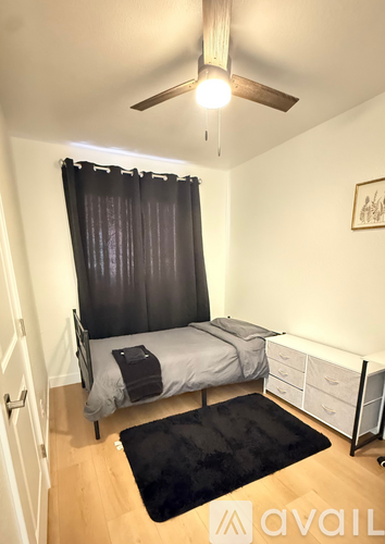 A bedroom with a bed, nightstands, and a ceiling fan.