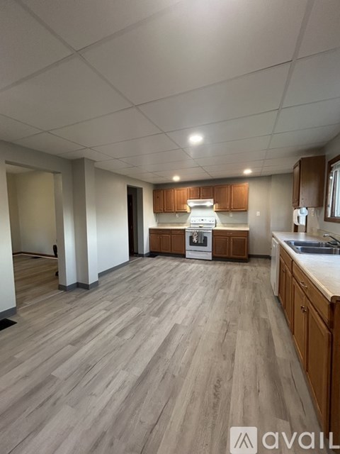 A kitchen with wooden floors and cabinets.