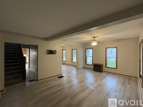 A spacious living room with a staircase and a television.