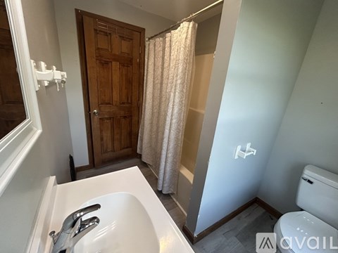 A bathroom with a white sink and a wooden door.