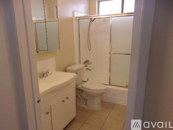A bathroom with a toilet, sink, and shower.
