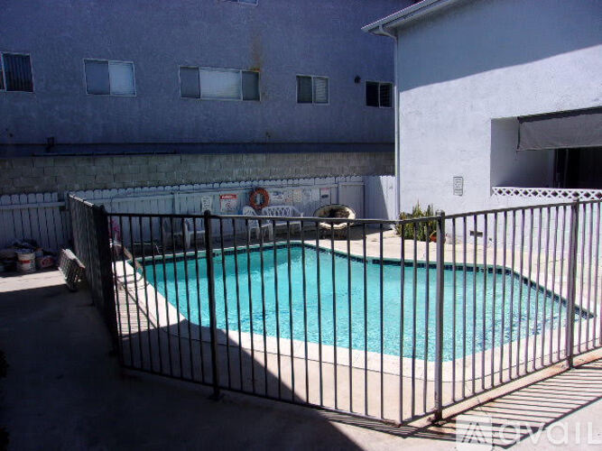 A black fence surrounds a small blue pool.