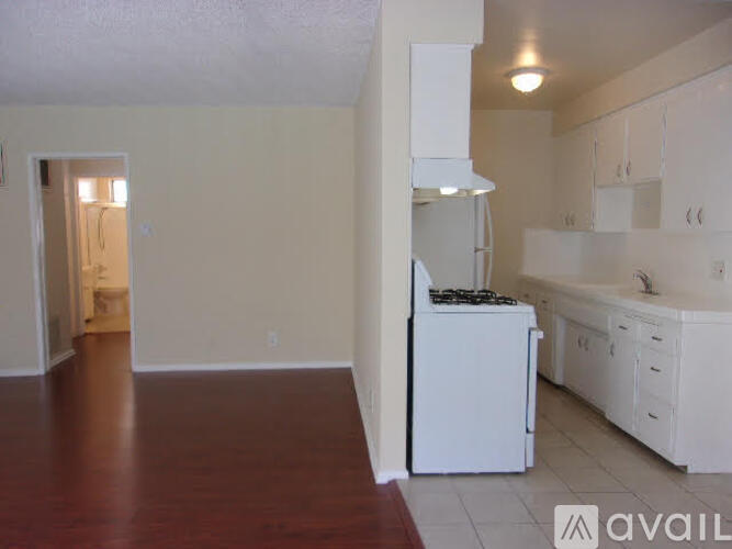 A kitchen with white appliances and cabinets.