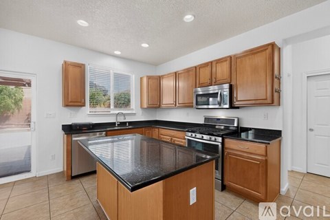 A kitchen with wooden cabinets and black countertops.