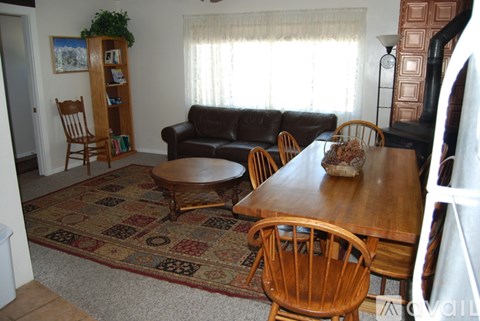 A living room with a couch, chairs, and a table.