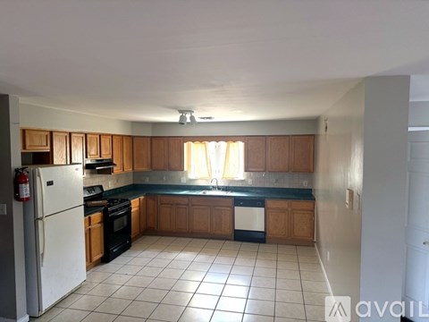 A kitchen with wooden cabinets and a white refrigerator.