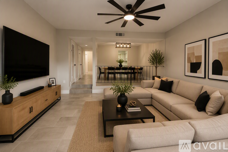 A modern living room with a large couch, a flat screen TV, and a coffee table.