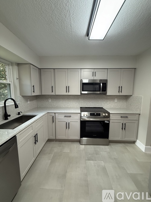 A kitchen with white cabinets and a stainless steel oven.