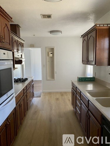 A kitchen with wooden cabinets and a white oven.