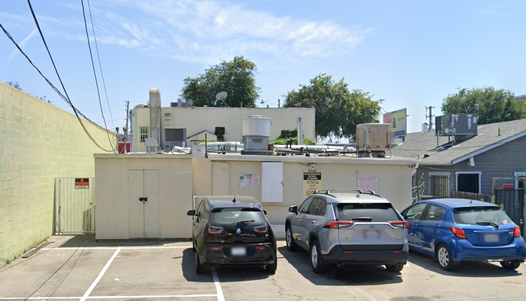Three cars are parked in a parking lot.