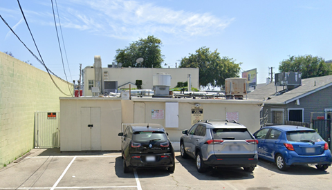 Three cars are parked in a parking lot.