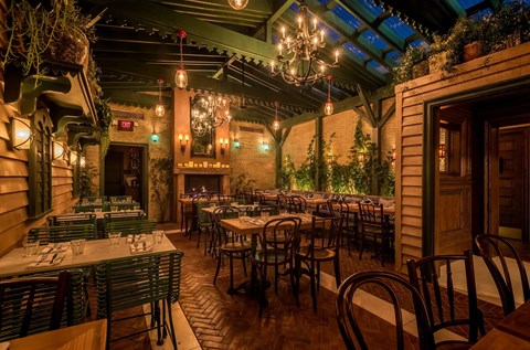 A restaurant with tables and chairs and a chandelier.
