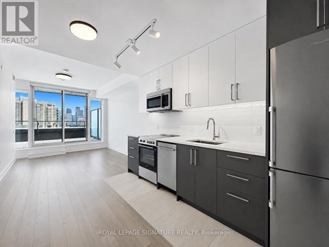 A modern kitchen with a refrigerator, oven, and microwave.