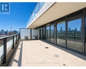 A balcony with glass doors overlooking a city skyline.