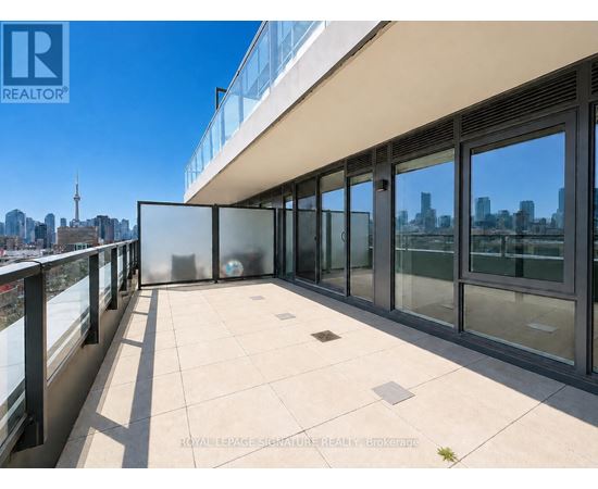 A balcony with glass doors overlooking a city skyline.