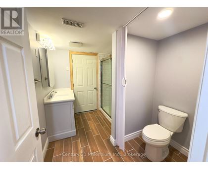 A bathroom with a toilet, sink, and mirror.