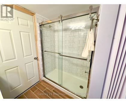 A white door is open to a bathroom with a glass shower stall.