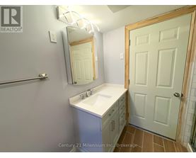 A bathroom with a sink, mirror, and a door.