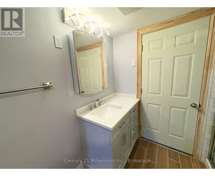 A bathroom with a sink, mirror, and a door.