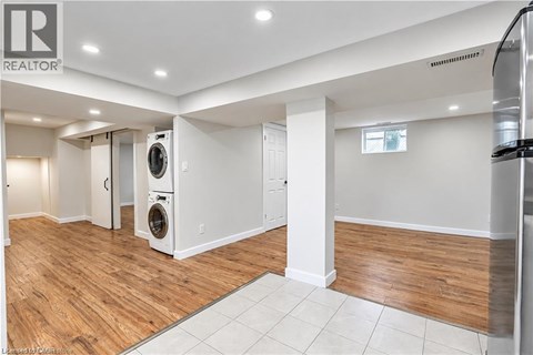 A large, empty room with a washer and dryer in it.