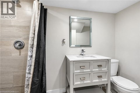 A bathroom with a sink, toilet, and a mirror.