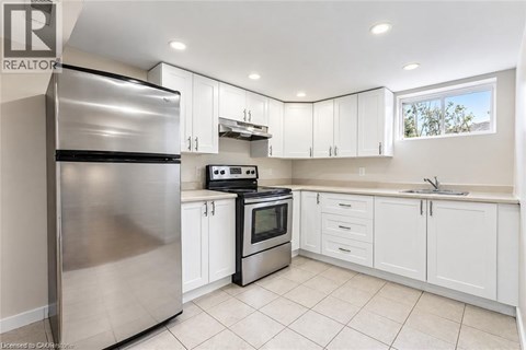 A modern kitchen with white cabinets and stainless steel appliances.