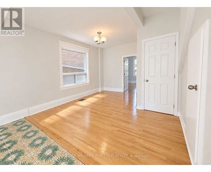 A room with a wooden floor and a rug with a geometric pattern.
