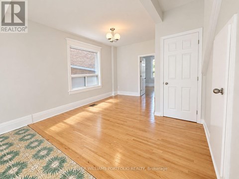 A room with a wooden floor and a rug with a geometric pattern.