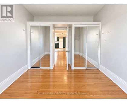 A room with a wooden floor and white walls, with a sliding door in the middle.