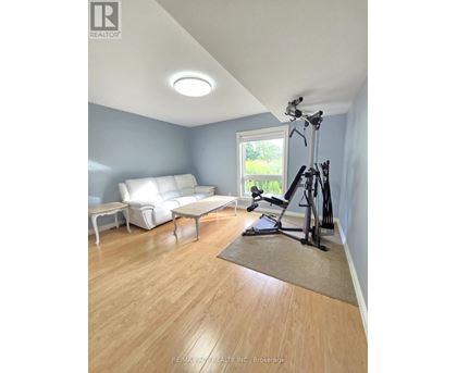 A living room with a white couch and a treadmill.