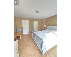 A bedroom with a bed, dresser, and nightstand.