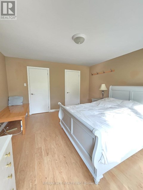 A bedroom with a bed, dresser, and nightstand.