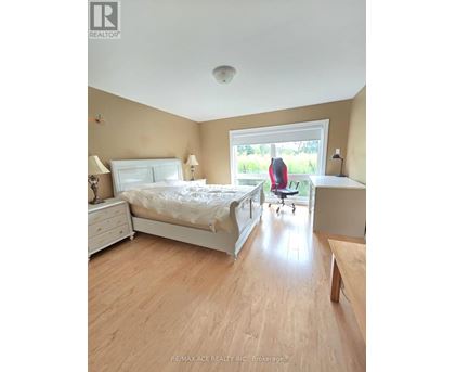 A bedroom with a bed, nightstand, and chair.
