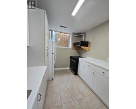 A kitchen with white cabinets and a black dishwasher.