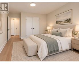 A bedroom with a large bed and a painting on the wall.