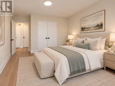 A bedroom with a large bed and a painting on the wall.