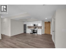 A spacious kitchen with wooden floors and modern appliances.