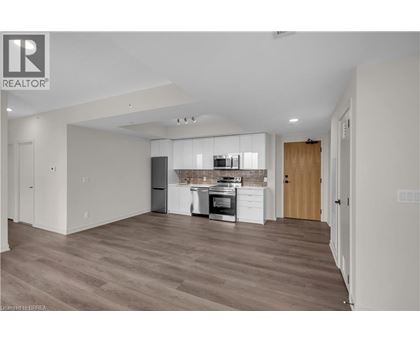 A spacious kitchen with wooden floors and modern appliances.