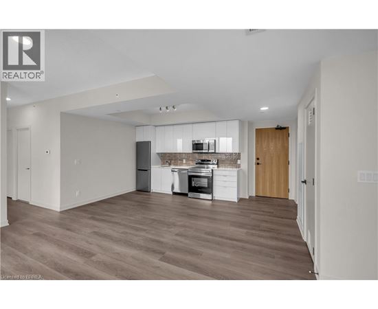 A spacious kitchen with wooden floors and modern appliances.