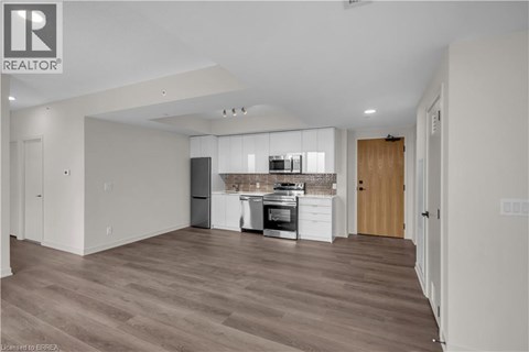 A spacious kitchen with wooden floors and modern appliances.