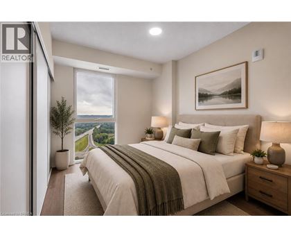 A bedroom with a large bed and a view of a winding road through the hills.